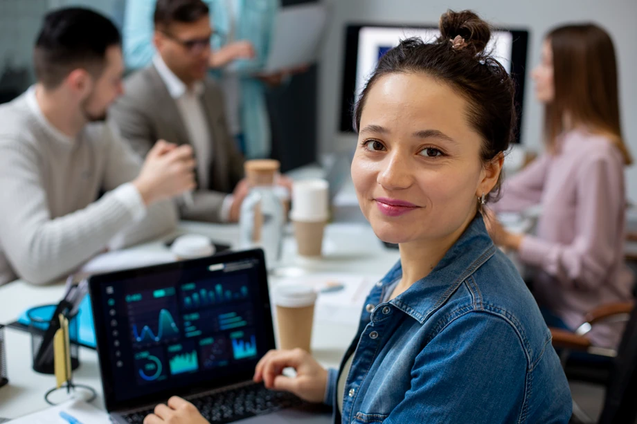 mujer sonriendo con compañeros de trabajo en el fondo
